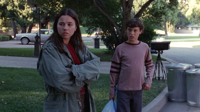 Lindsay (Linda Cardellini) and Sam (John Francis Daley) standing on a curb on Freaks and Geeks S1E4