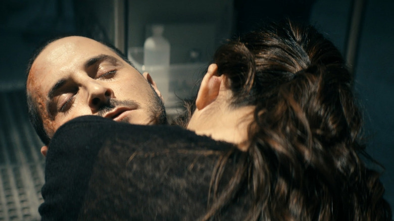 Kimiko (Karen Fukuhara) holding a dying Frenchie (Tomer Capone) on 