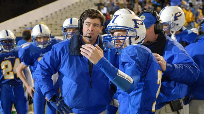 Coach Eric Taylor talking to Matt in blue football uniform