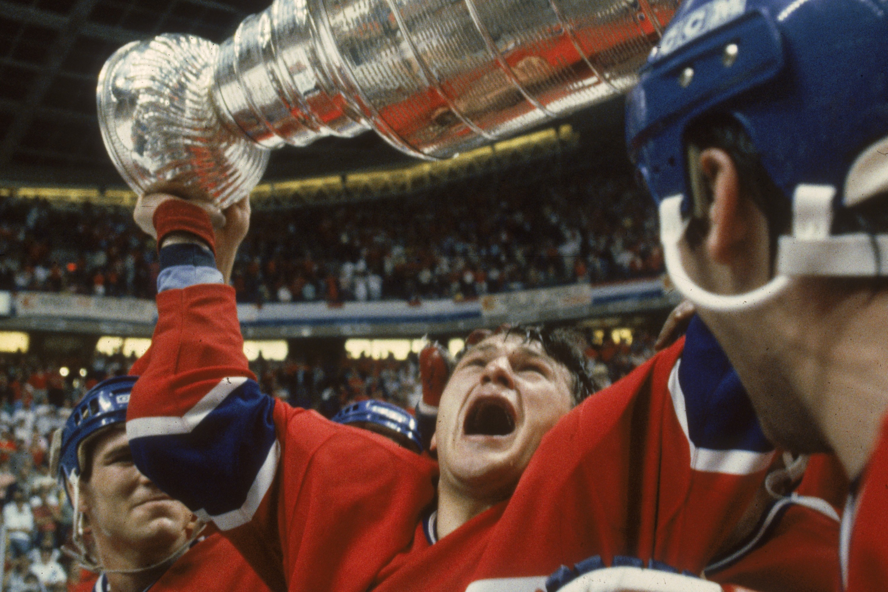 Claude Lemieux yells as he holds the Stanley Cup over his head.