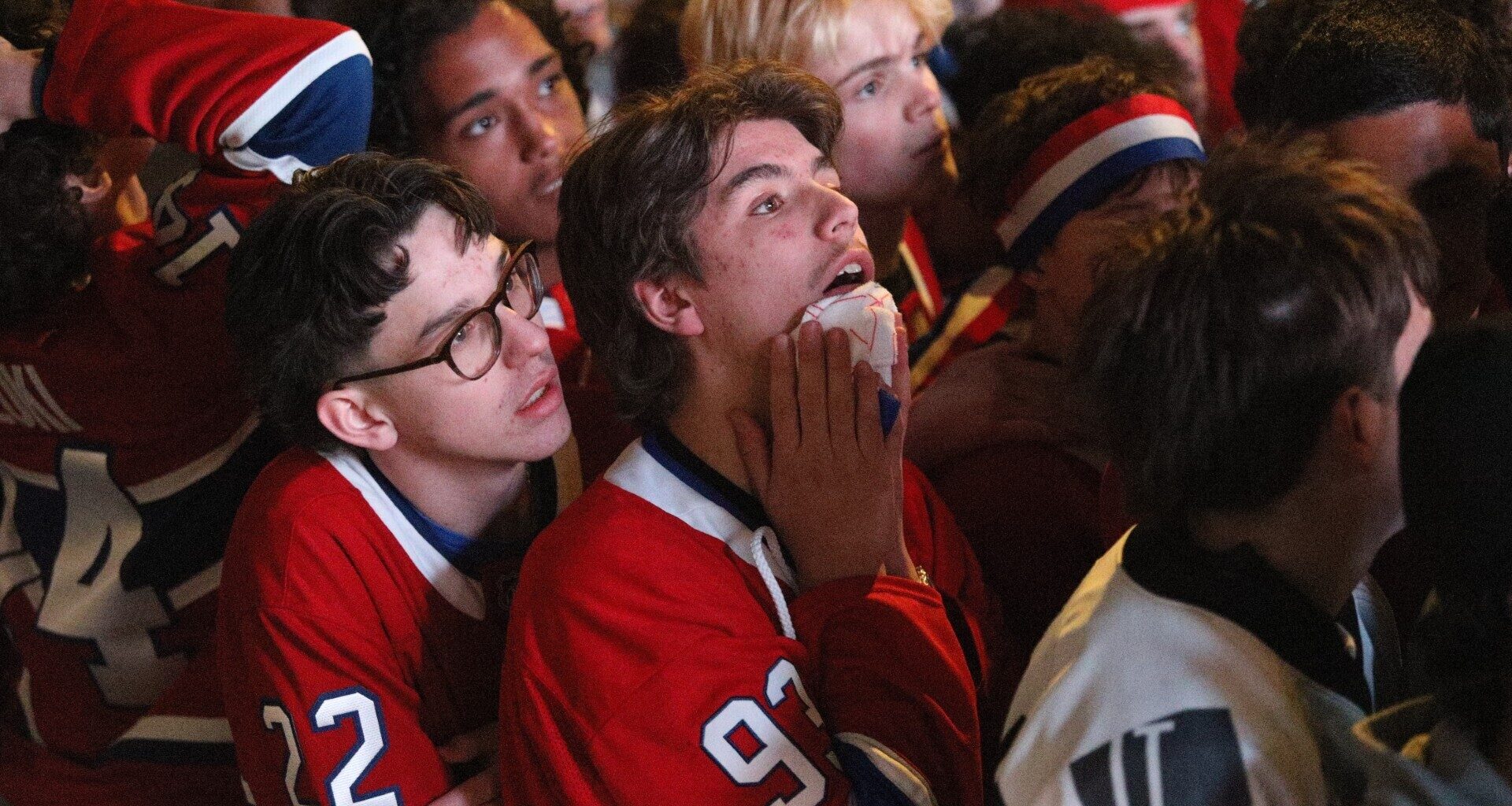 Hockey fans react after their team is defeated in overtime.