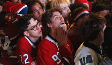 Hockey fans react after their team is defeated in overtime.