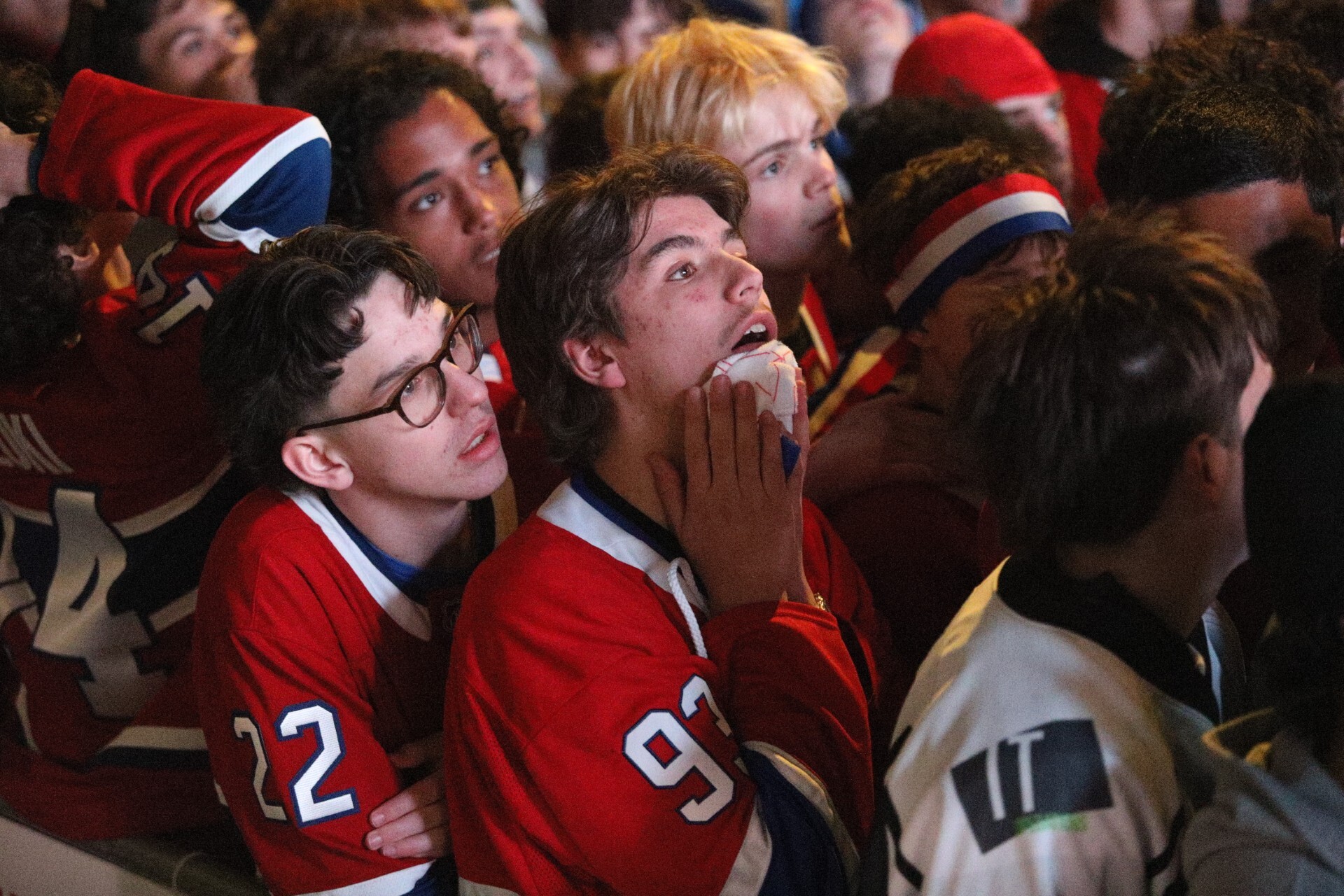 Hockey fans react after their team is defeated in overtime.