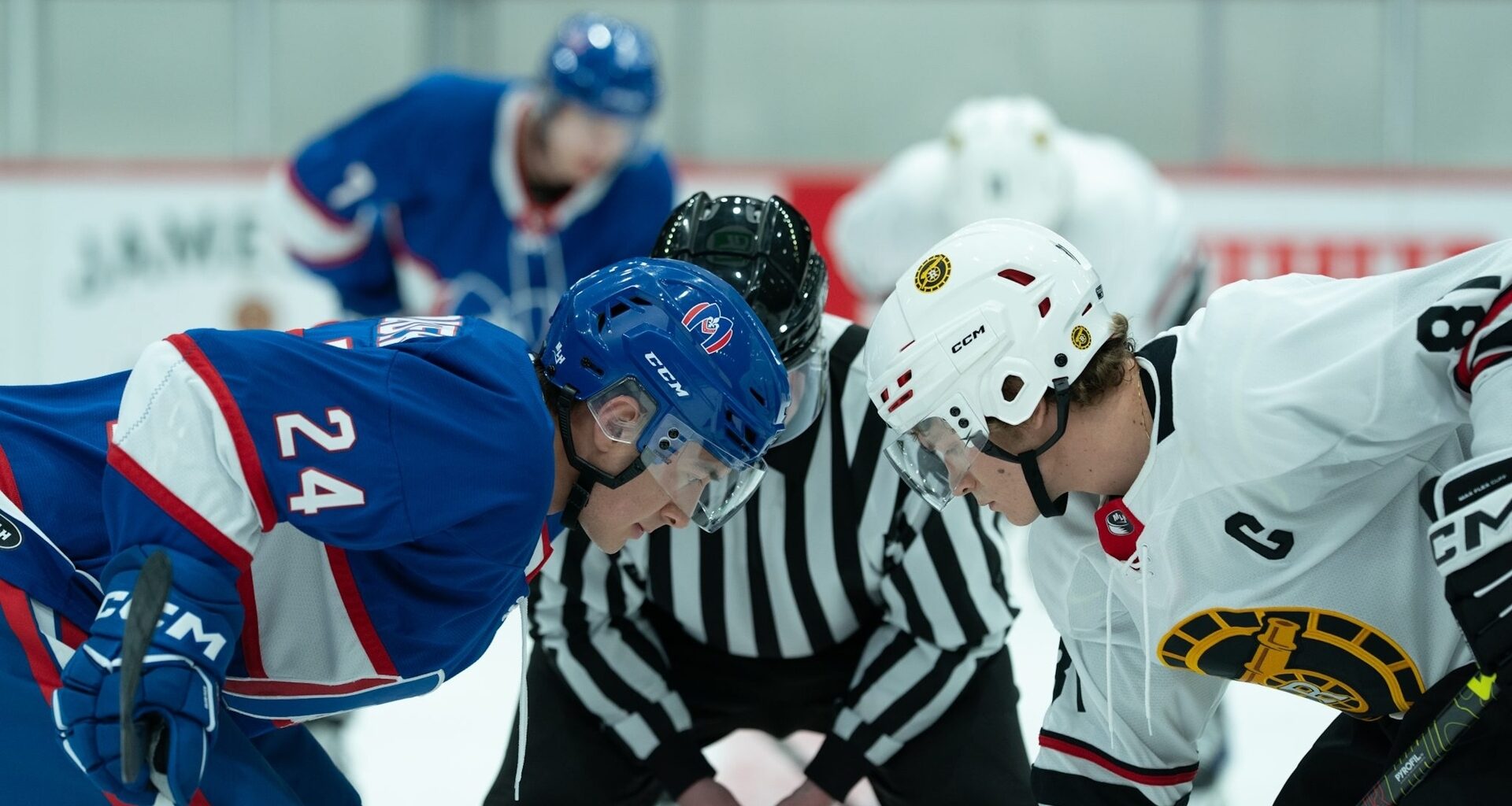 Two hockey players facing off at centre ice.