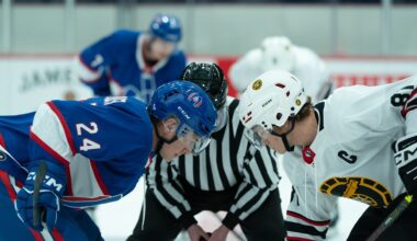 Two hockey players facing off at centre ice.