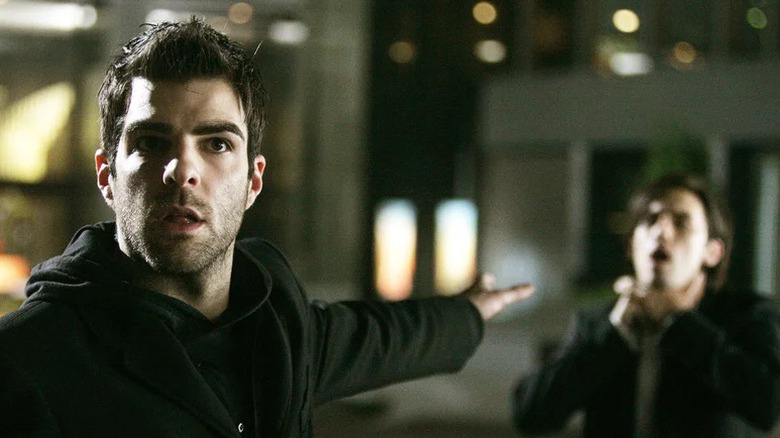 Zachary Quinto as Sylar holding hand out and telepathically choking Milo Ventimiglia as Peter (blurry in background) in Heroes