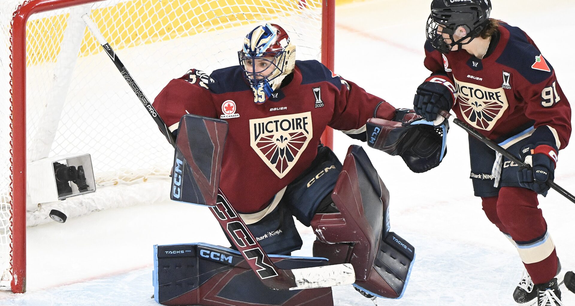 A women's hockey goalie fails to stop a goal.
