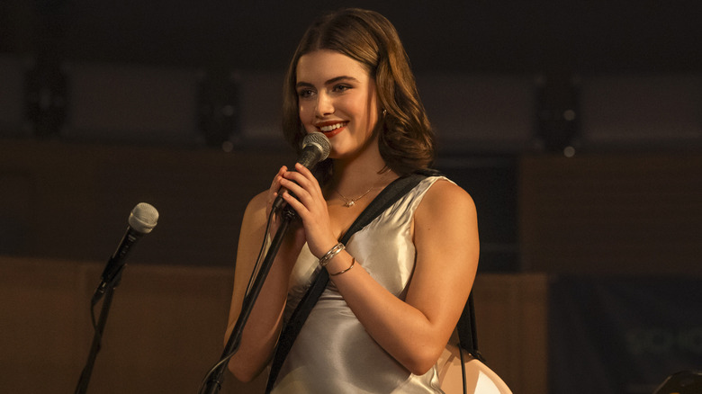 Hannah holding a mic and smiling on stage
