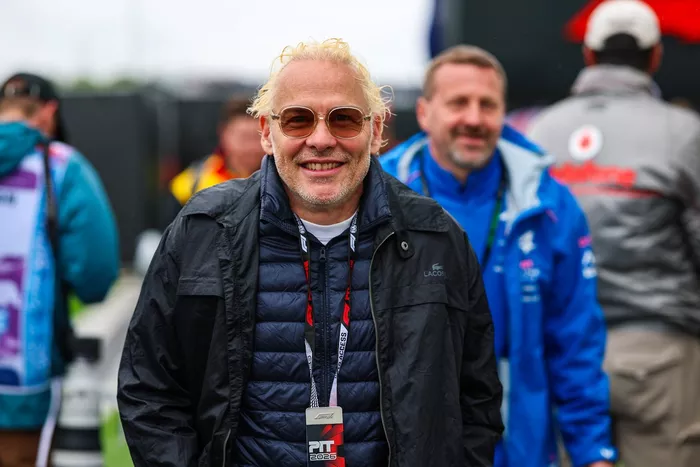 Jacques Villeneuve, former racing driver, walks in the paddock.