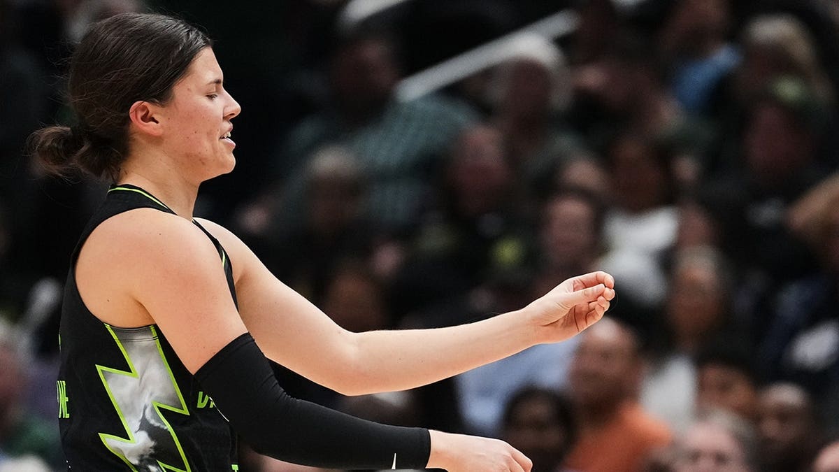 Seattle Storm guard Jade Melbourne holding out half of her knocked-out tooth during a basketball game