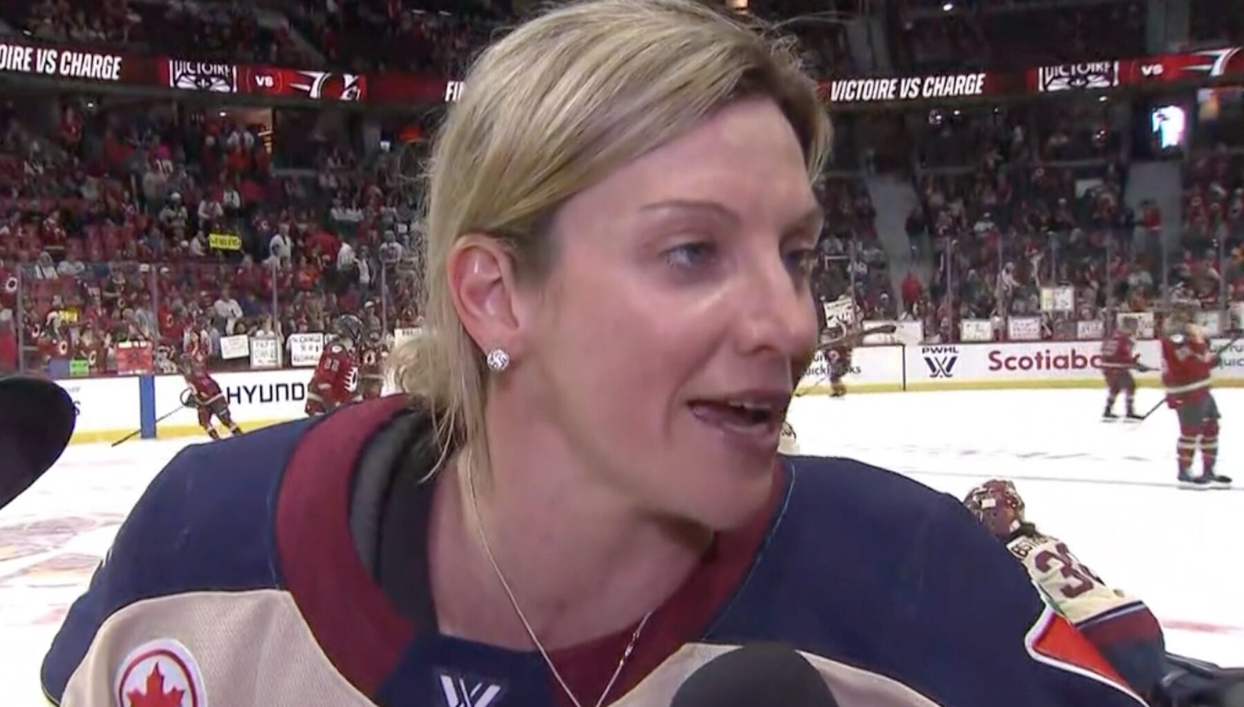 Laura Stacey does an interview on TV while on the ice.