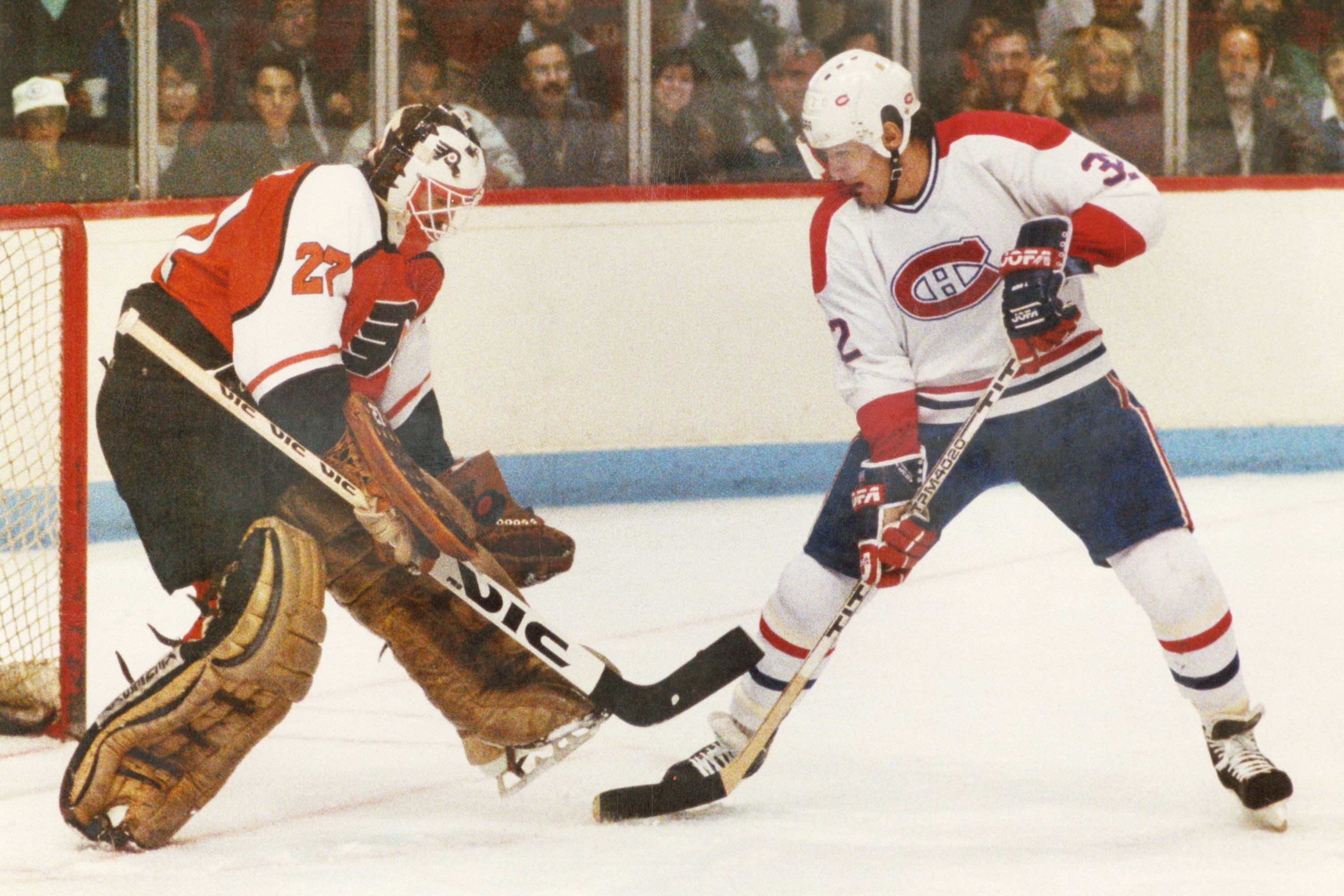Hockey goalie in 1987 stops a shot by Canadiens' Claude Lemieux.