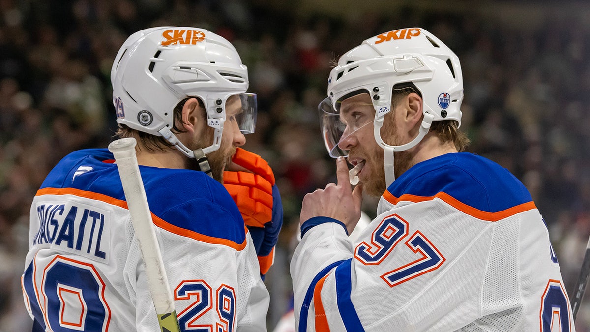 Edmonton Oilers forwards Leon Draisaitl and Connor McDavid talking on ice