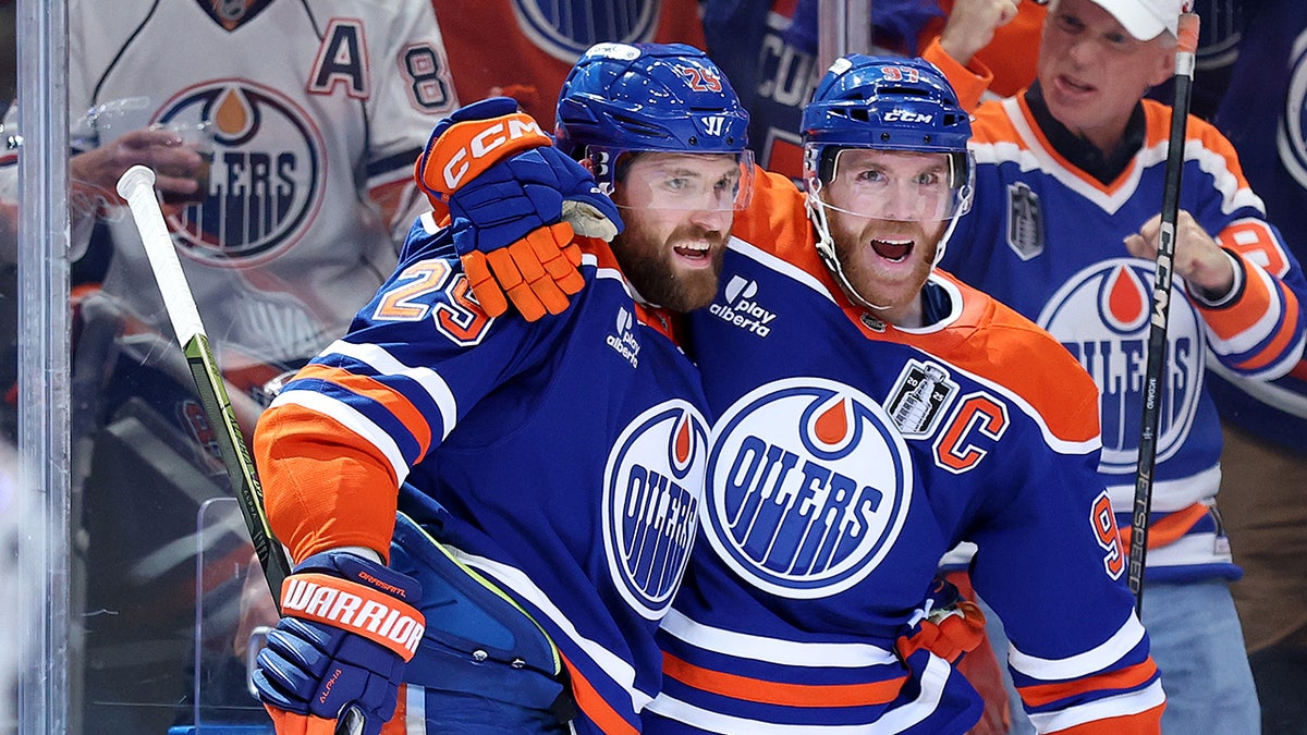 Leon Draisaitl and Connor McDavid celebrating during a hockey game at Rogers Place.