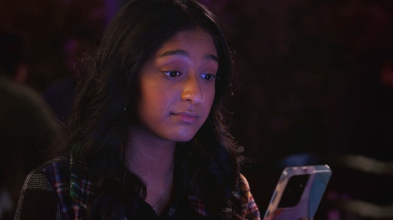 Devi (Maitreyi Ramakrishnan) looking at her phone on Never Have I Ever S4E5