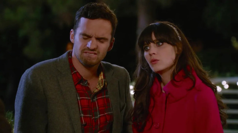 Jake Johnson as Nick cringing next to Zooey Deschanel as Jess