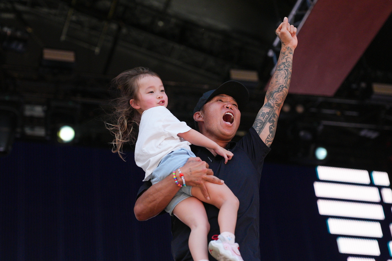 Anthony Kim of the United States (R) celebrates with his daughter Bella after winning LIV Golf Adelaide at Grange Golf Club in Adelaide, Australia, on Feb. 15. (EPA-Yonhap)