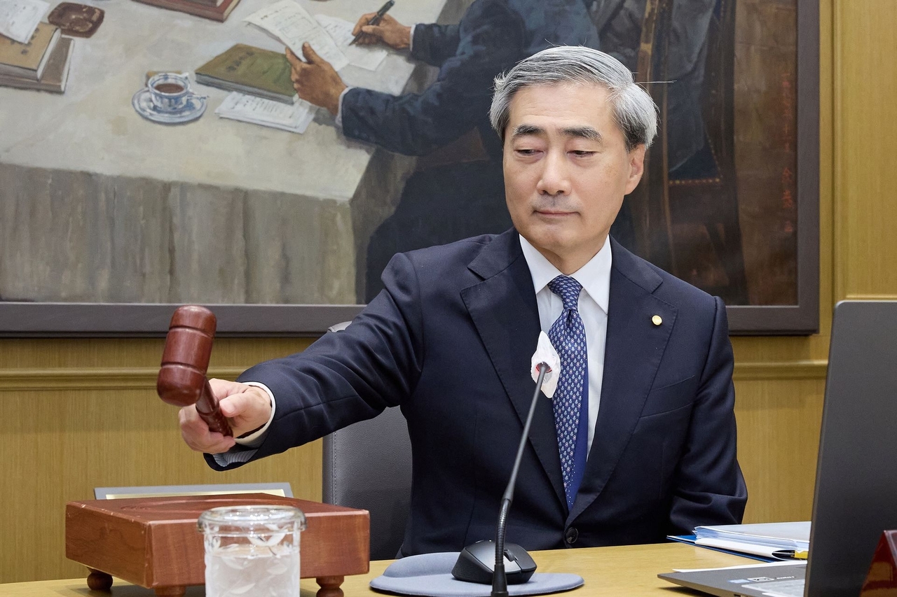 BOK Gov. Shin Hyun-song bangs the gavel at a rate-setting meeting held at the central bank's headquarters in Seoul, Thursday. (Bank of Korea)