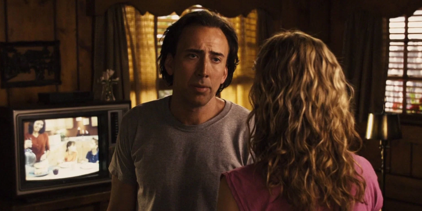 A man looks past a girl in a dark motel room