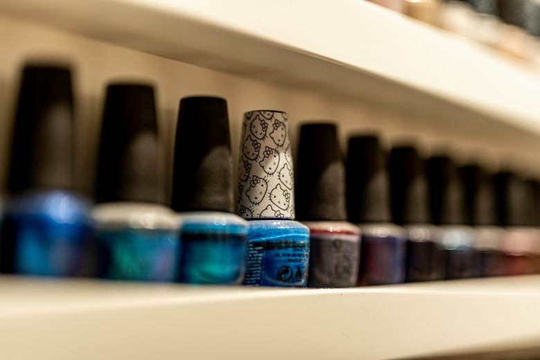 A row of brightly coloured bottles of nail polish. One with a "Hello Kitty" lid is highlighted.