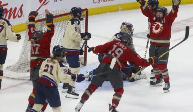 Ottawa Charge's Rebecca Leslie throws her hands up in the air as teammates also celebrate outside the Montreal net