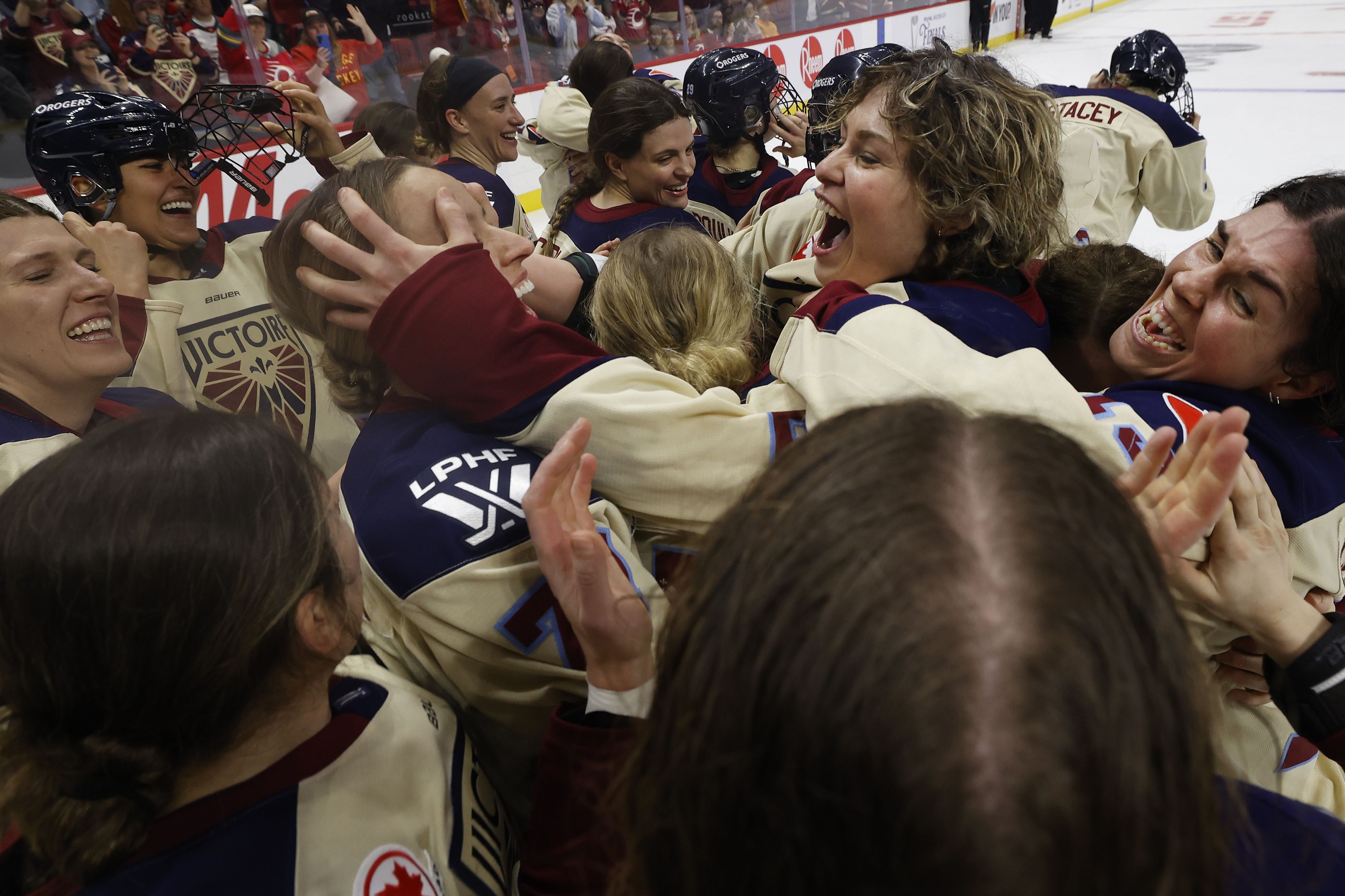 Victoire players embrace each other in celebration.