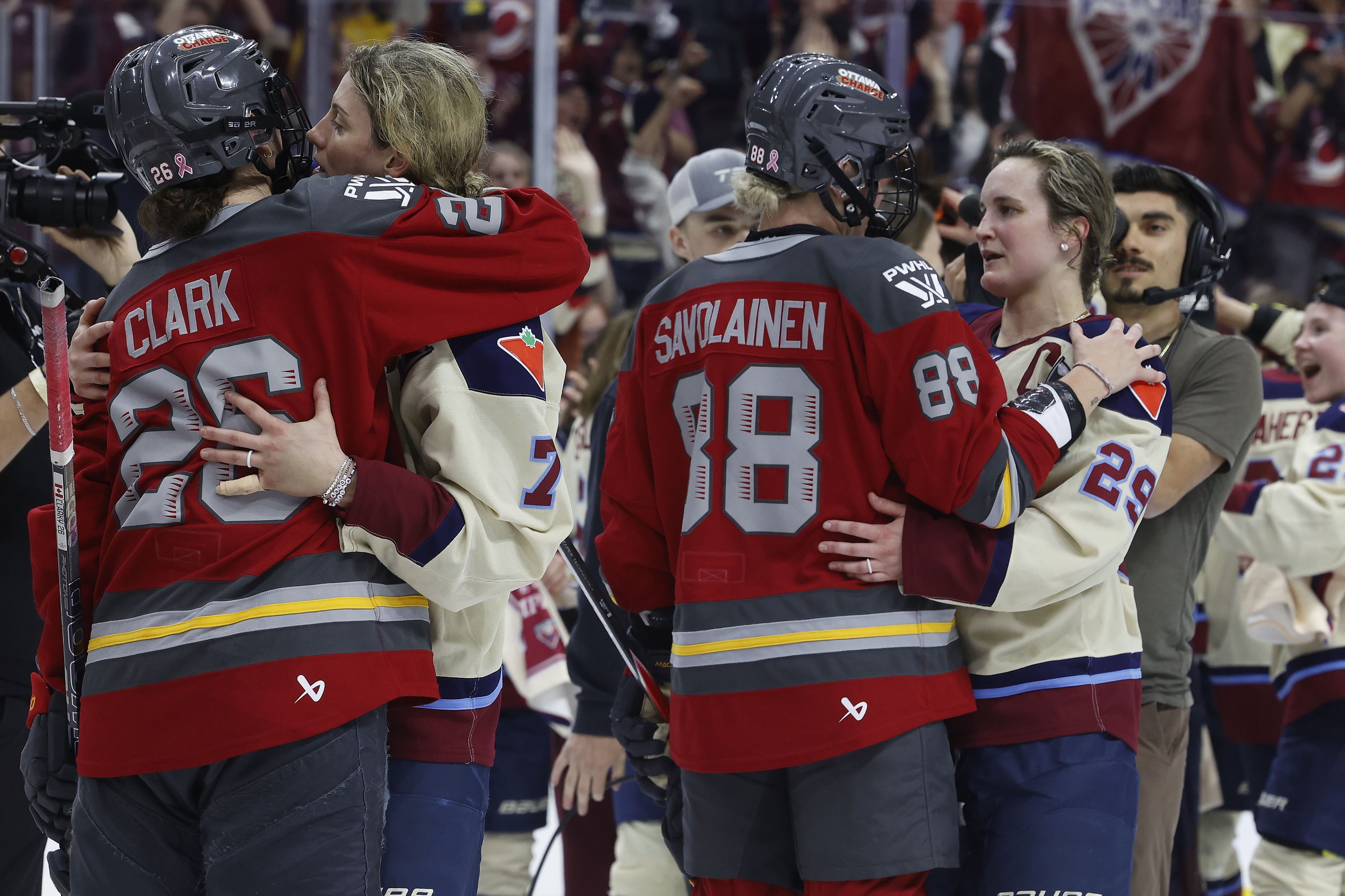 Ottawa Charge and Montreal Victoire players shake hands and hug.