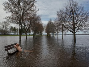 Ėrik Thuswaldner relaxes by a flooded park bench at Britannia Bay.