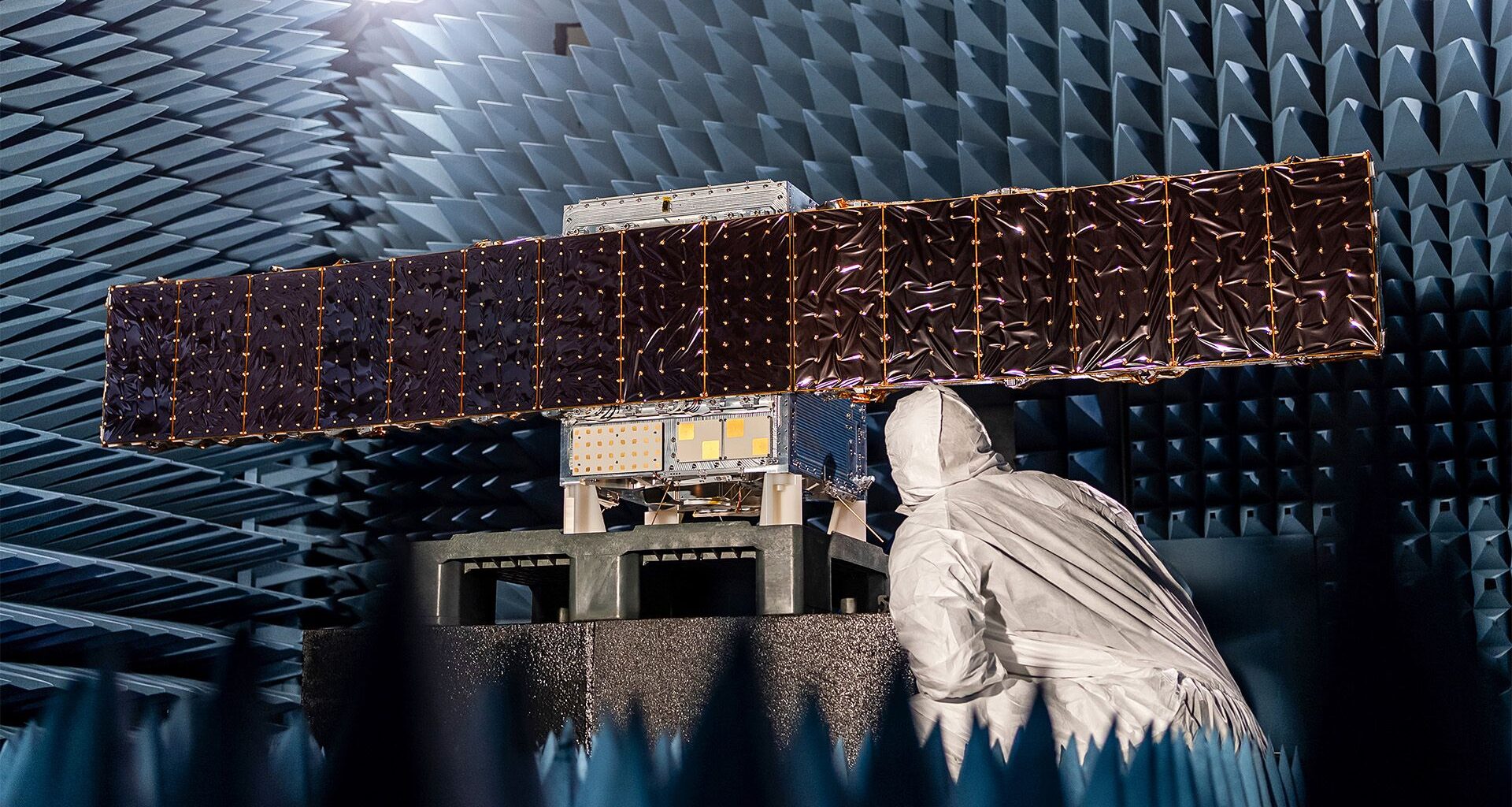 an illustration of a cube-shaped spacecraft with two wing-like solar panels