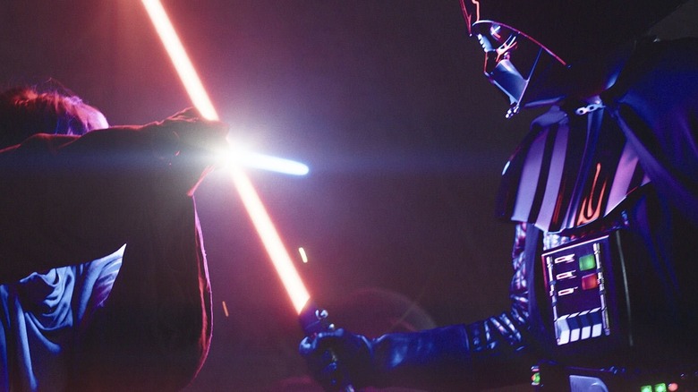 Darth Vader and Obi-Wan lock lightsaber blades in a nighttime duel