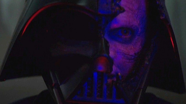 Anakin Skywalker looks out through the cracked mask of Darth Vader