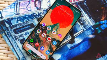 The Pixel 9 Pro on a wicker table and lying on top of an album sleeve with the display up