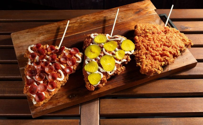 A deep-fried slice of Pizza 73 cheese pizza coated in corn dog batter and heavily dusted with orange Cheetos seasoning.