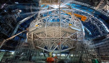 Today's Picture of the Week gives an exclusive view into the heart of ESO's Extremely Large Telescope (ELT). While the exterior appears to be almost ready for action, work is ongoing inside to complete the telescope’s structure, illuminated here by the Sun shining through the open, gigantic doors. This structure is the heart of the ELT and will host the telescope’s mirrors, which will gather the light and send it to the instruments at the sides of the telescope. At the bottom part of the structure, the cell for the main mirror is visible. The tube above connects the main mirror structure with the top ring — the spider structure that holds the secondary mirror crown. Three additional mirrors will be hosted in a tower at the centre of the main mirror, not seen here. Once the light reaches one of the platforms at the side of the telescope, an extra mirror will redirect it to one of the several scientific instruments that will analyse it. With its 39-metre-diameter, the main mirror will be the largest ever for an optical telescope, making the ELT the biggest eye on the night sky. Consequently, the technical requirements are as extreme as the ELT's name suggests. Everything about this telescope is larger than anything built before, making it the prototype that must perform perfectly, to enable us to explore the universe deeper and sharper than ever before.