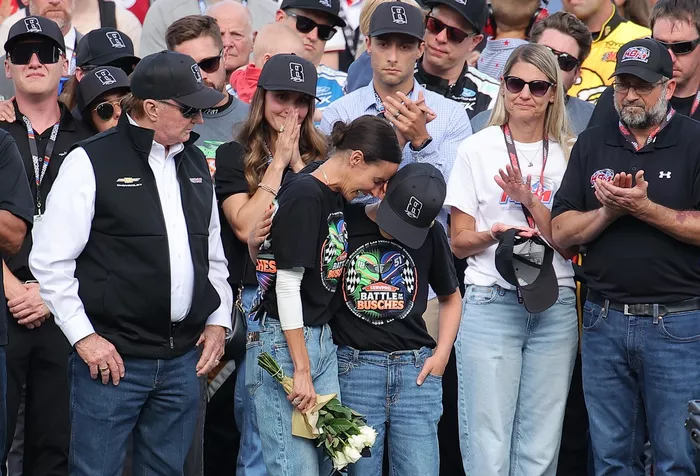 Samantha Busch (wife) and Brexton Busch (son) embrace one another on the grid during the remembrance ceremony for Kyle Busch