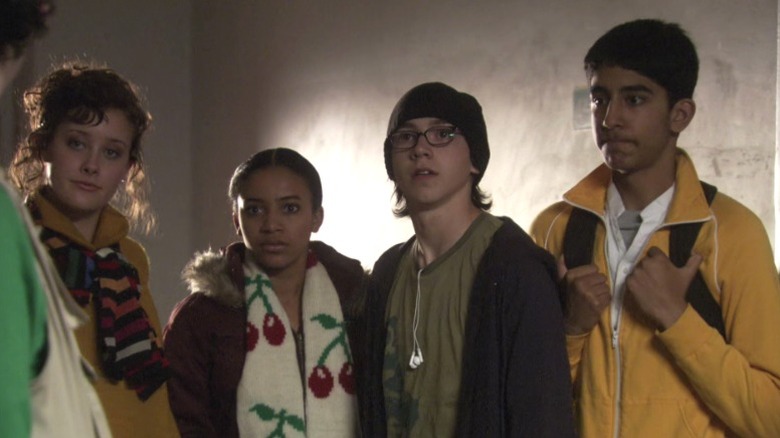 Michelle (April Pearson), Jal (Larissa Wilson), Sid (Mike Bailey), and Anwar (Dev Patel) standing together awkwardly on Skins S1E6