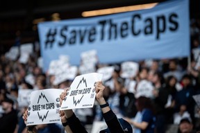 Vancouver Whitecaps fans hold signs before the first half of an MLS soccer match against the Colorado Rapids in Vancouver, on Saturday, April 25, 2026.