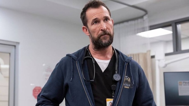 Dr. Robbie in sweatshirt with stethoscope around his neck, looking on