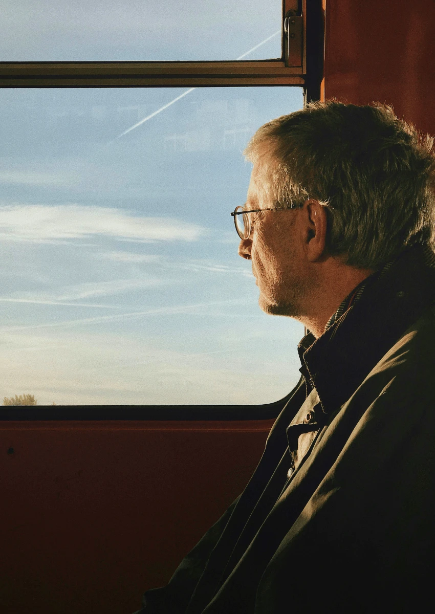 thoughtful older man looking out of window