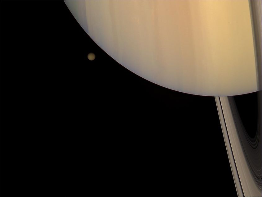 The colorful globe of Titan, Saturn's largest moon, photographed by NASA's Cassini orbiter passing in front of Saturn and its rings.