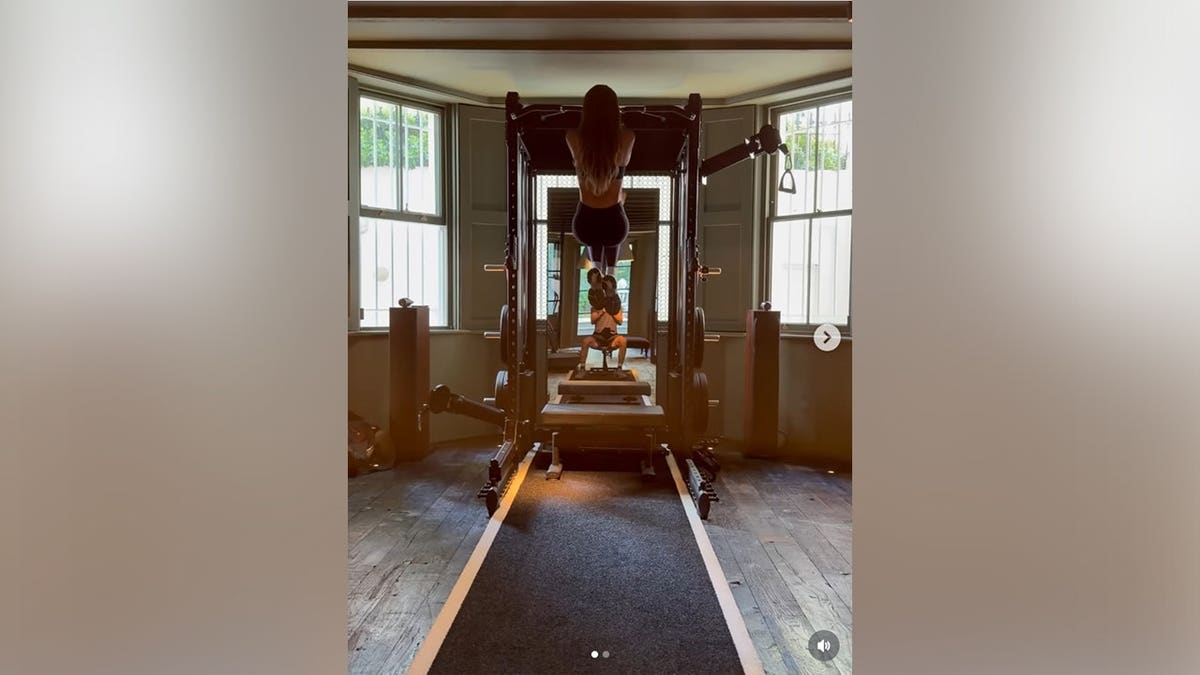 A picture of Victoria Beckham doing pull-ups from the back.
