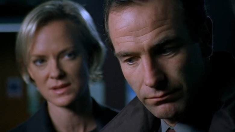 Carol Jordan standing behind Robson Green and speaking to him