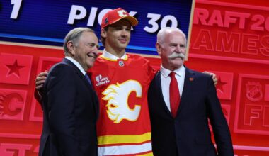 Jun 26, 2026; Buffalo, New York, USA; Jack Hextall reacts beside NHL commissioner Gary Bettman and former NHL player Lanny McDonald after being selected with the thirtieth pick in the first round of the 2026 NHL Draft by the Calgary Flames at KeyBank Center. Mandatory Credit: Timothy T. Ludwig-Imagn Images