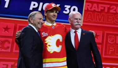 Jun 26, 2026; Buffalo, New York, USA; Jack Hextall reacts beside NHL commissioner Gary Bettman and former NHL player Lanny McDonald after being selected with the thirtieth pick in the first round of the 2026 NHL Draft by the Calgary Flames at KeyBank Center. Mandatory Credit: Timothy T. Ludwig-Imagn Images