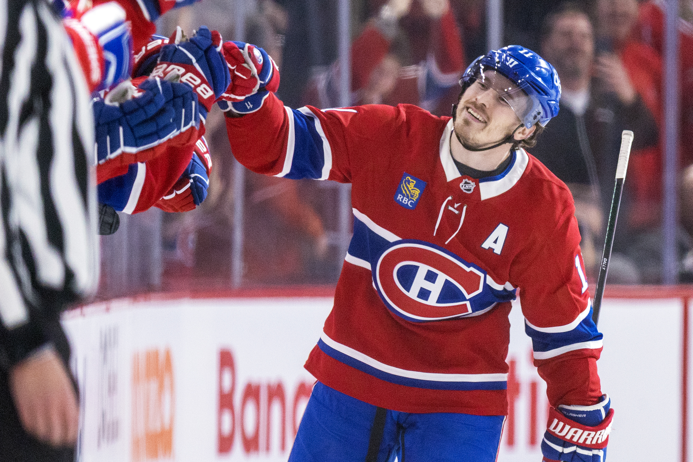 Brendan Gallagher skates by the Canadiens bench bumping fists.