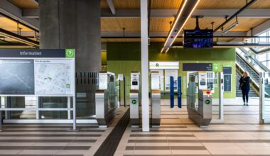 Turnstiles, escalators and information boards leading to a REM station.