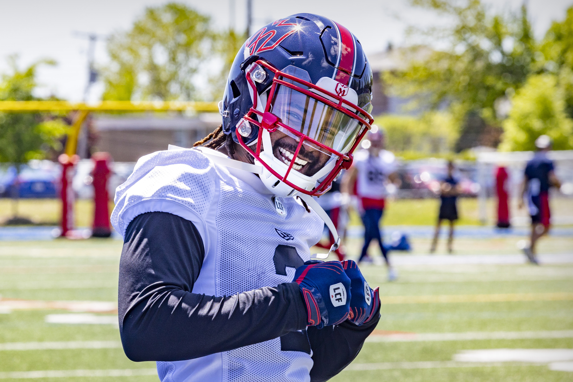 Mario Alford smiles posing for a photo at an outdoor practice.