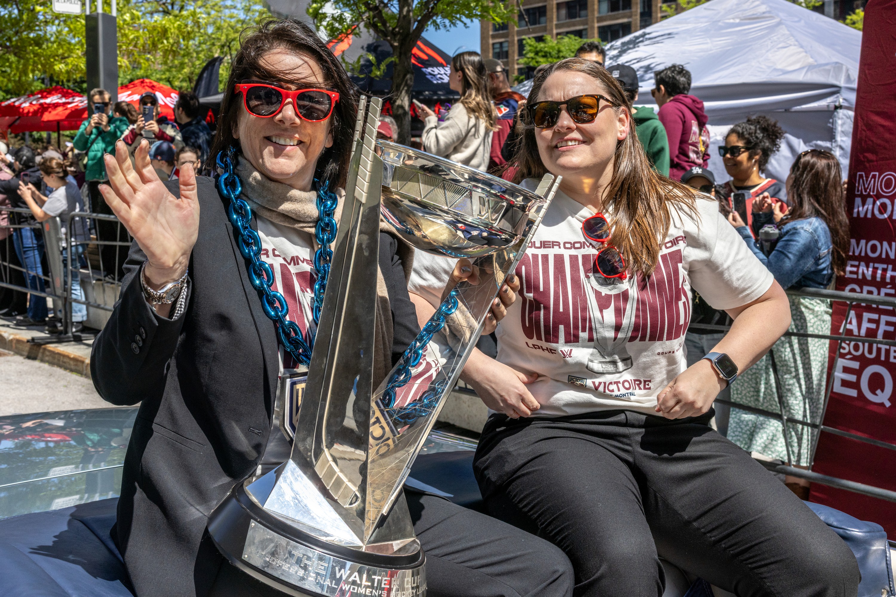 Montreal Victoire general manager Danièle Sauvageau and coach Kori Cheverie with the Walter Cup, as they sit in a car in a victory parade.