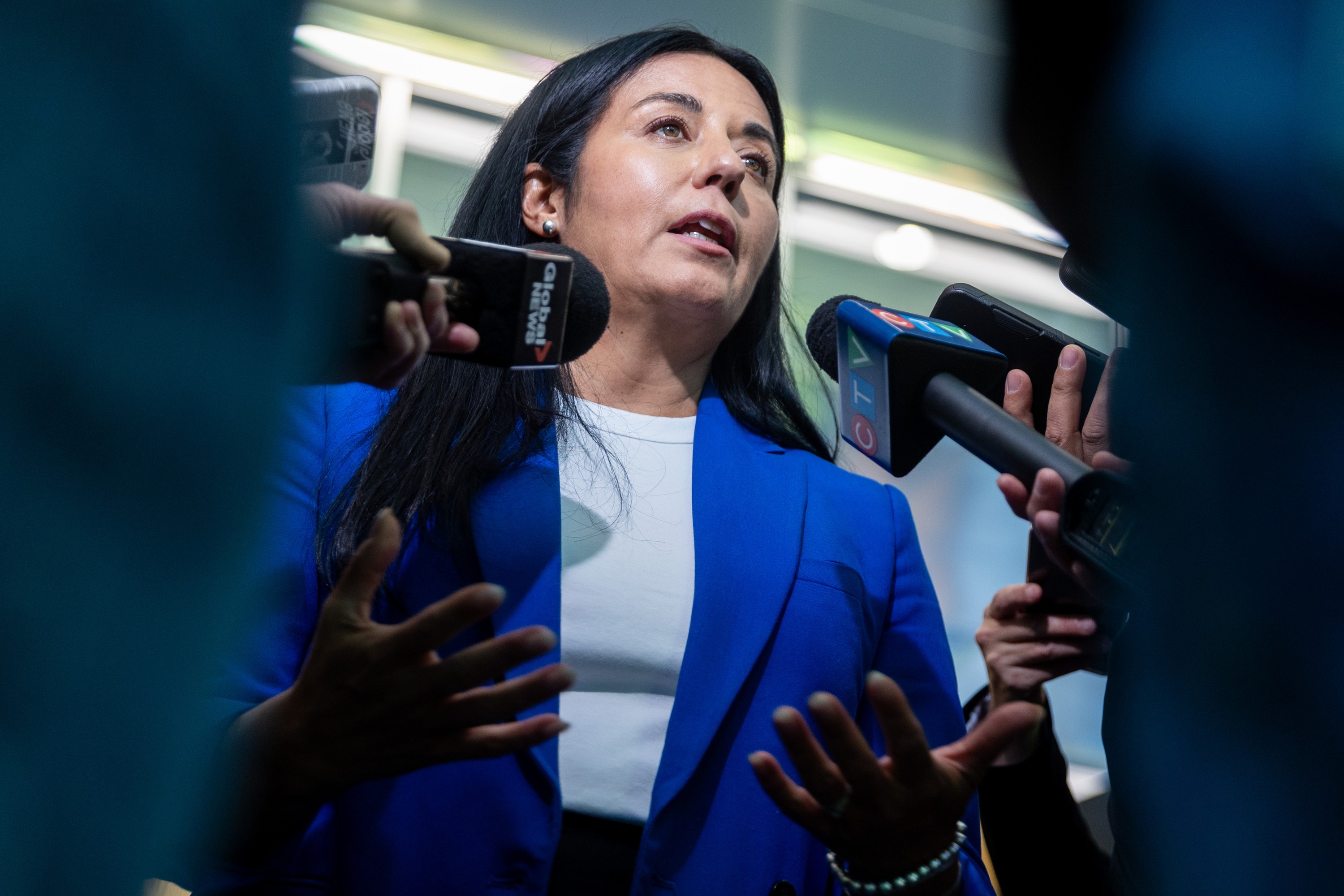 Soraya Martinez Ferrada is seen from a low angle in a scrum of journalists.