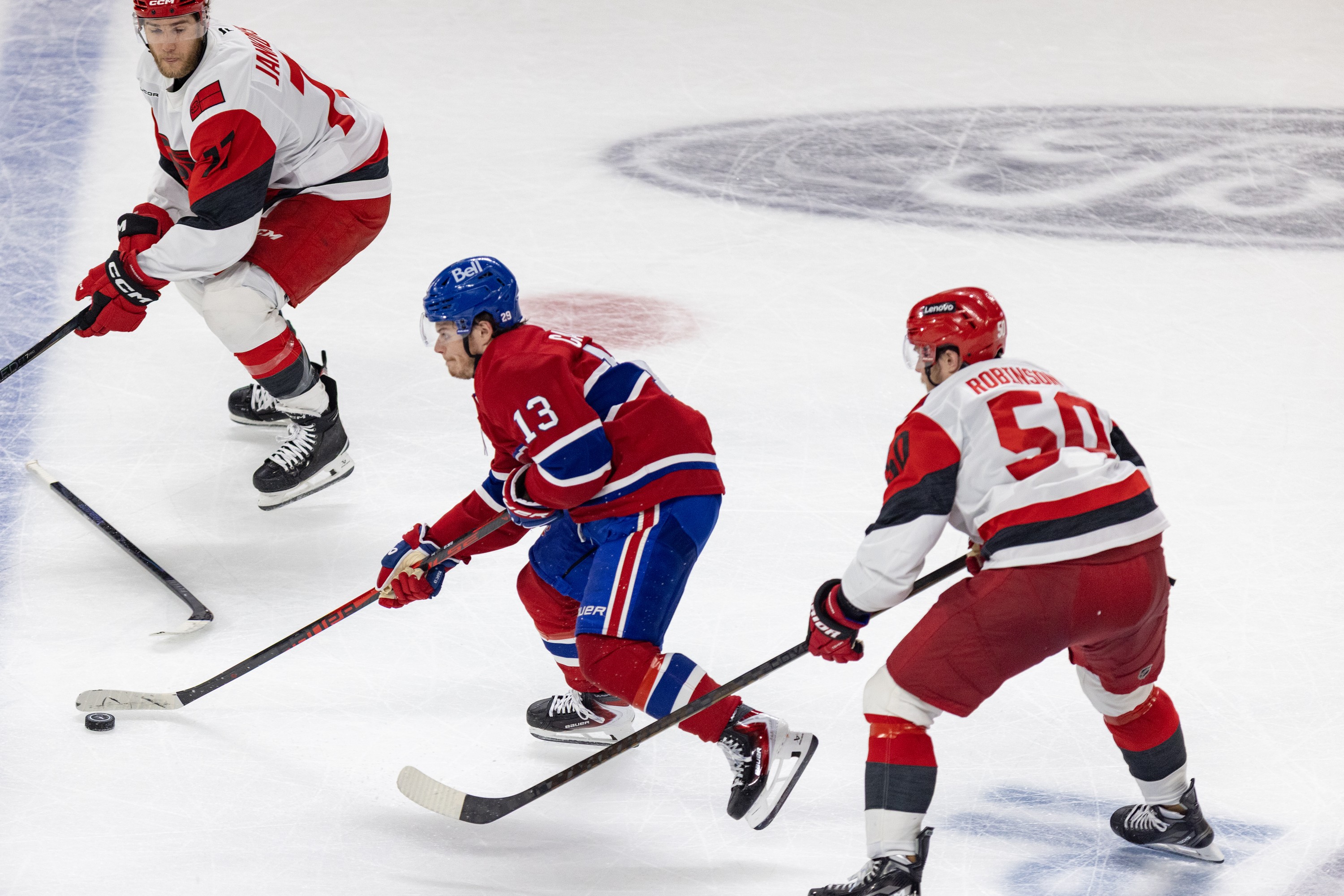 Canadiens winger Cole Caufield carries the puck toward the Carolina Hurricanes' blue line between Mark Jankowski, left, and Eric Robinson during third period of Game 3 in Montreal on May 25.